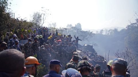 Rescuers gather at the site of a plane crash in Pokhara.