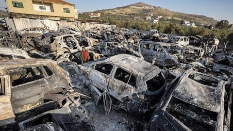 A man stands amidst destroyed cars at a scrapyard in the town of Huwara near Nablus in the occupied West Bank on Monday after they were torched overnight.