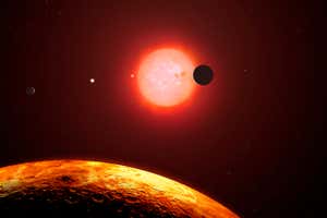 Trappist-1 is a red-dwarf star, the most common variety, located some 40 light-years away in Aquarius. In 2015, astronomers discovered that Trappist-1 was host to three earth-sized planets. Then it came under the spotlight again in 2017 when NASA scientists found an additional four planets, taking the total up to seven. This is the most terrestrial planets that have ever been found to orbit a single star, including our own Solar System. Trappist-1 is only fractionally larger than Jupiter in diameter. This image shows the star and six of the planets as they would appear from the vantage point of the fifth outermost planet, Trappist-1f. All of the planets and the Sun are to scale. One of the worlds is seen transiting in front of the star.