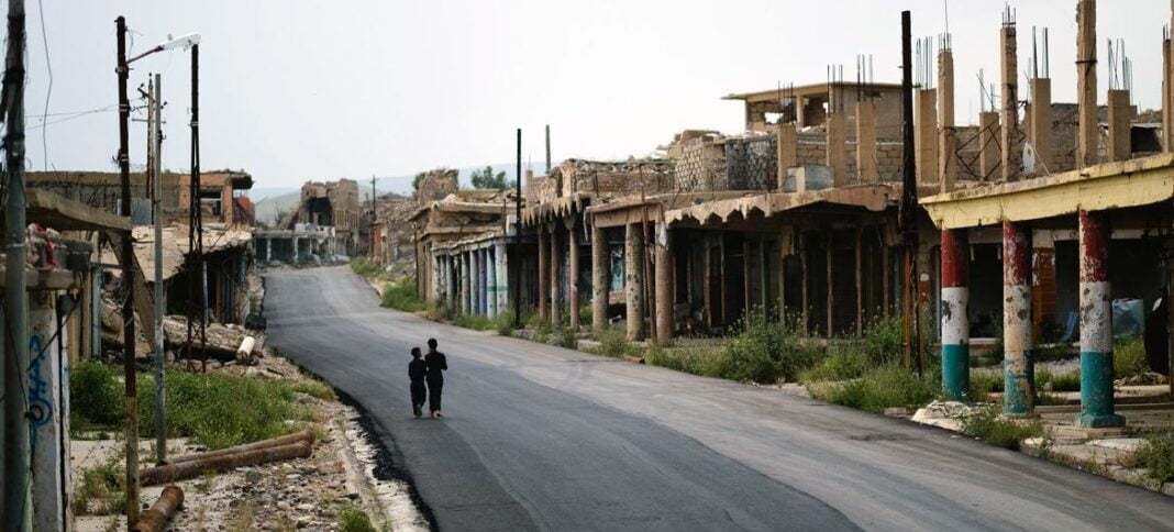 Iraqi children walk past a marketplace in Sinjar which was ruined in the war with the Da'esh terrorist network, otherwise known as ISIL.