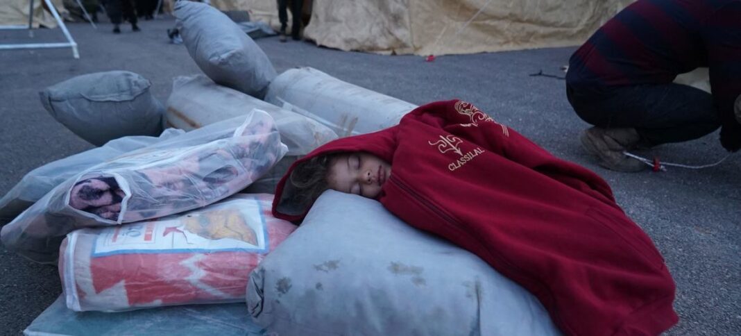 A child sleeps on relief items at a reception centre in Jandairis town in northern Syria.