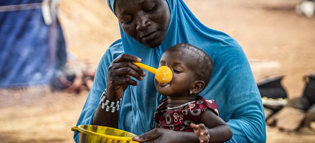 A mother gives her 10-month-old daughter porridge in Burkina Faso in the Sahel region, where WFP is providing assistance to prevent malnutrition.