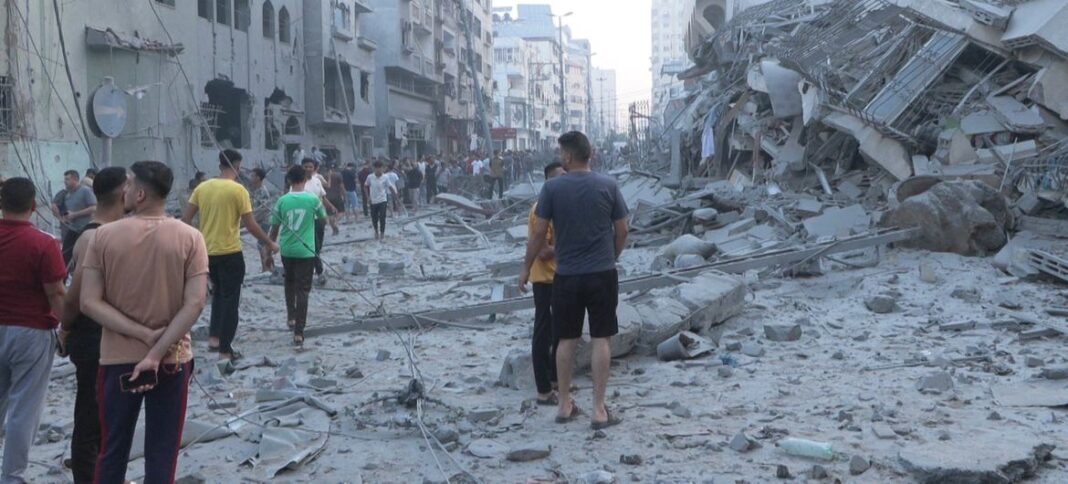 Men walk through a heavily damaged area of central Gaza.