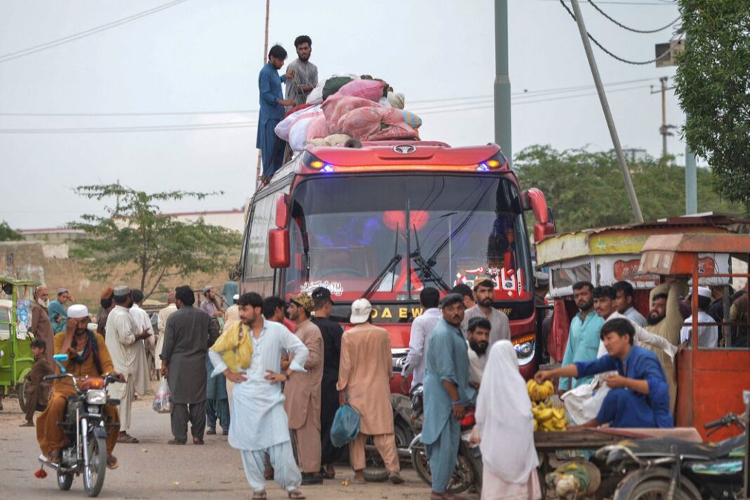 Afghan refugees board a bus from Karachi to Afghanistan on September 21.