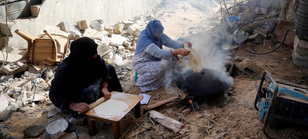 Women bake bread surrounded by destroyed buildings in Khan Yunis, Gaza during the recent humanitarian pause.